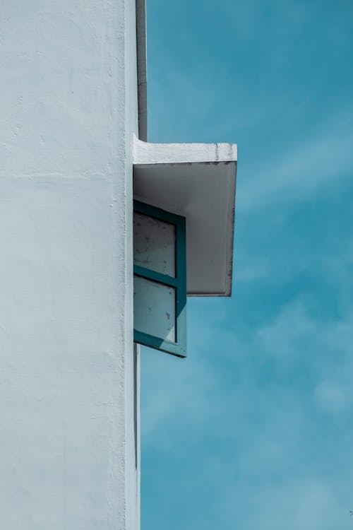 White Concrete Wall with Blue Window under Blue Sky