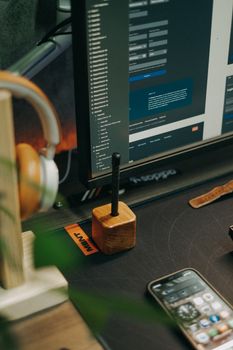 A sleek workspace featuring a computer monitor, smartphone, and headphone on a table.