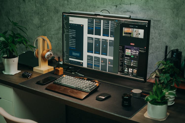 Flowerpots On Desk With Computer