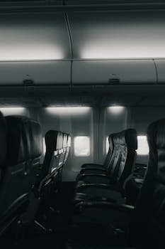 A moody grayscale shot of empty airplane seats capturing a quiet interior ambiance.