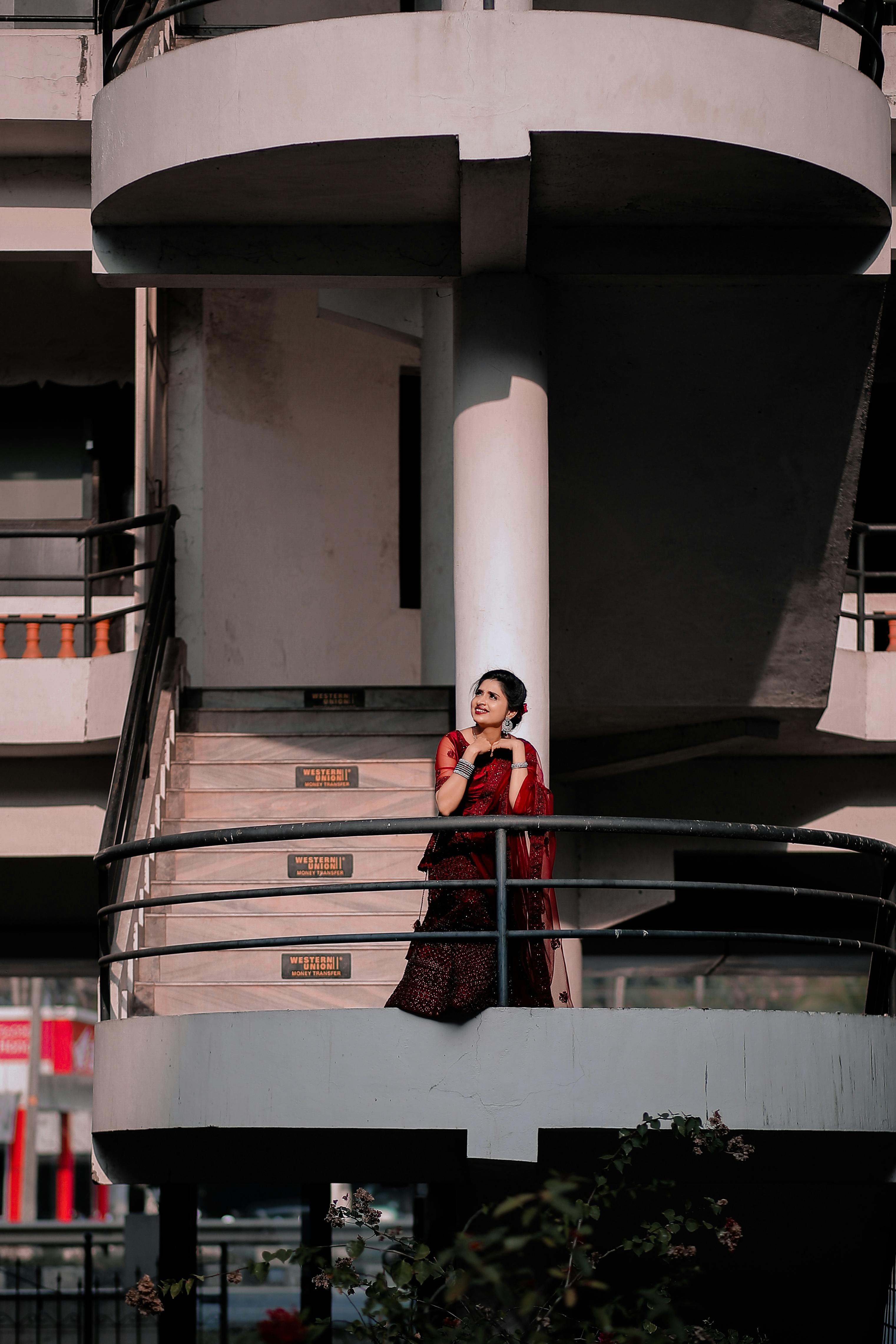 a woman in red dress standing at the stairs