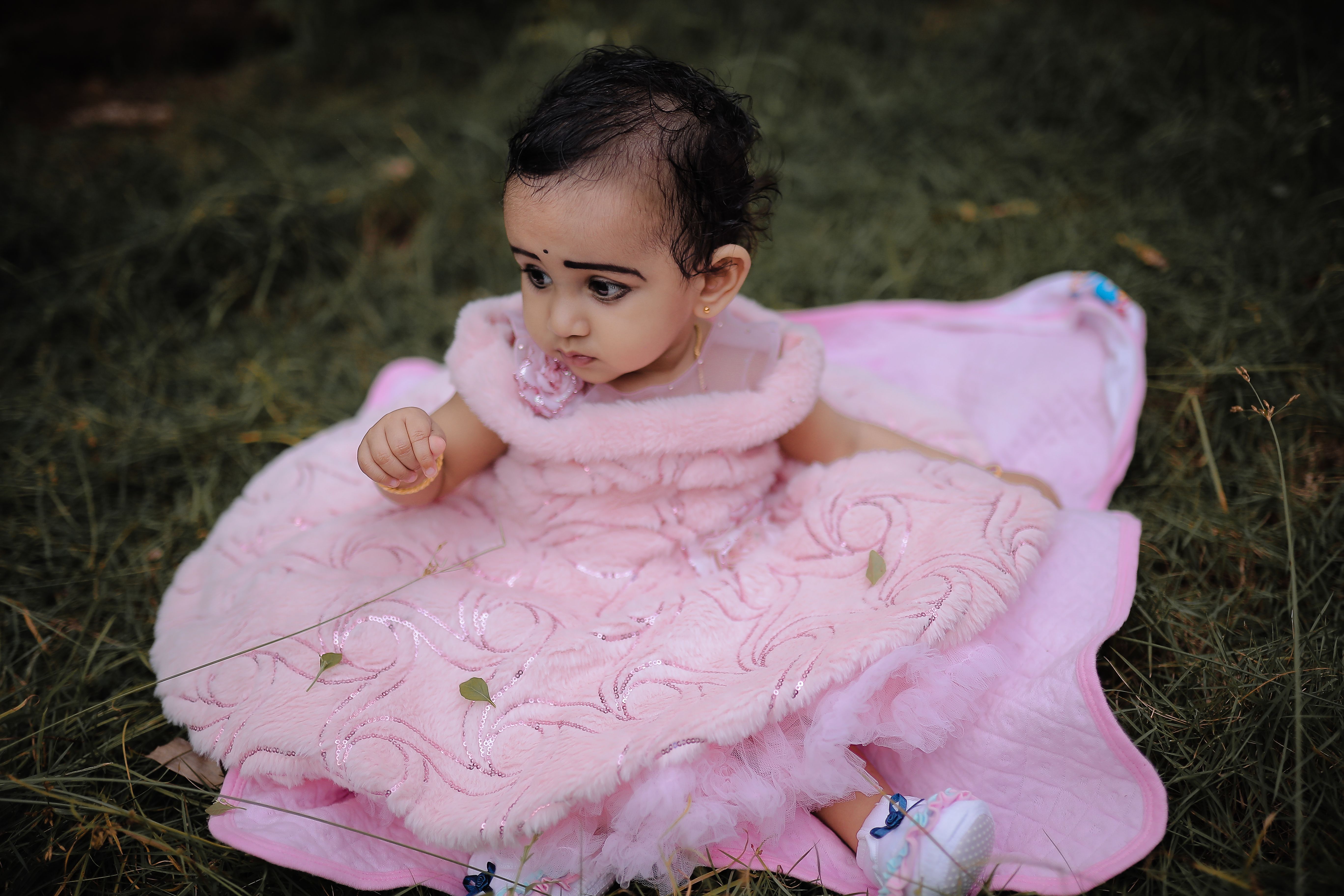 baby-in-pink-dress-sitting-on-grass-free-stock-photo