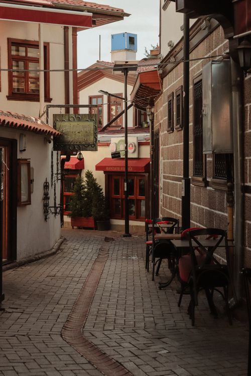 Free Explore a quaint, narrow street in historical Ankara, showcasing charming cafes and shops. Stock Photo