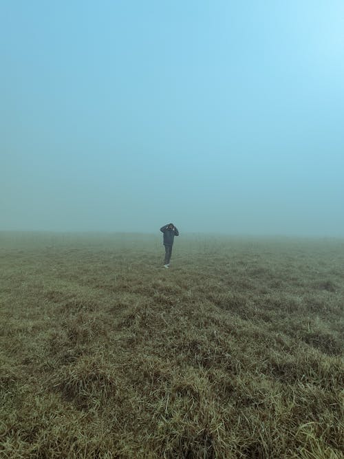 Fog over Person Standing on Grassland