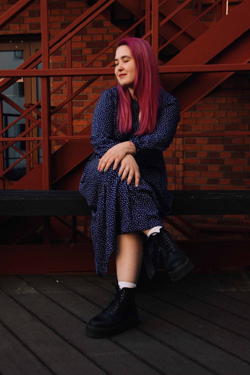 Woman in a Dress Sitting while Her Eyes are Closed