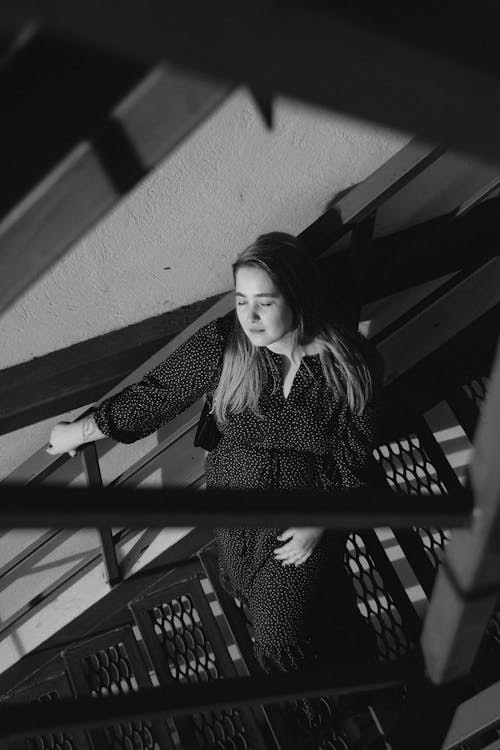 Grayscale Photo of a Woman Posing on the Stairs