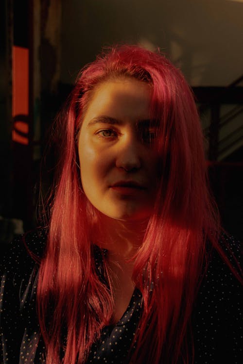 A Woman with Pink Hair Looking at the Camera