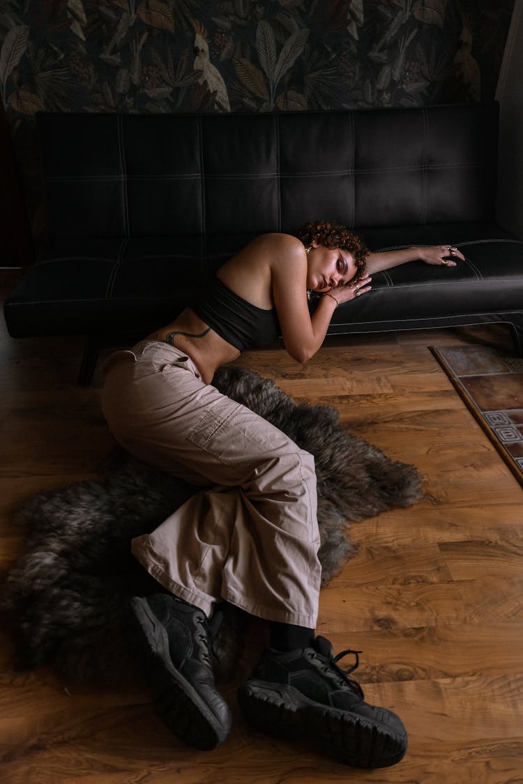 Woman Lying On Fur Carpet In Dark Interior