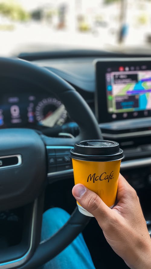 A Person Holding Brown and Black Disposable Cup