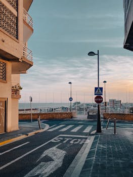 Scenic urban street view with road signs and skyline in Tarragona, Spain at dusk.