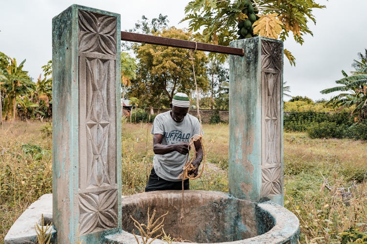 Man Pulling Bucket Out Of Well