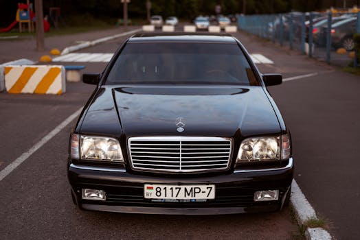 Classic Mercedes Benz sedan parked on the road, showcasing front view with license plate visible.