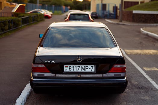 Back view of a classic Mercedes Benz S500 parked on an urban street, showcasing luxury automotive design.