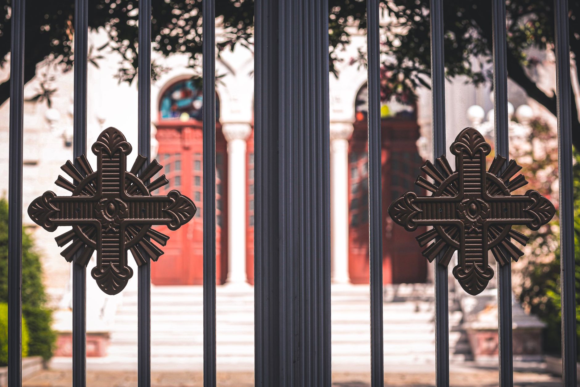Close-up of a church entrance featuring ornamental metal gates with decorative crosses.