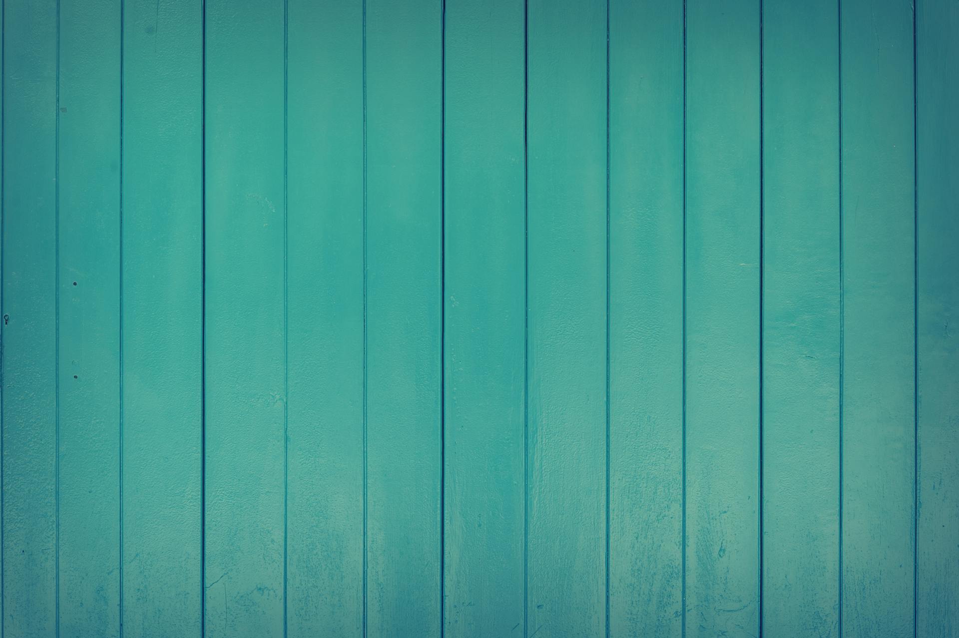 A vibrant teal wooden panel texture perfect for design and backgrounds.