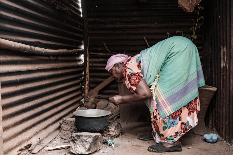 Old Woman Cooking Food In Bard