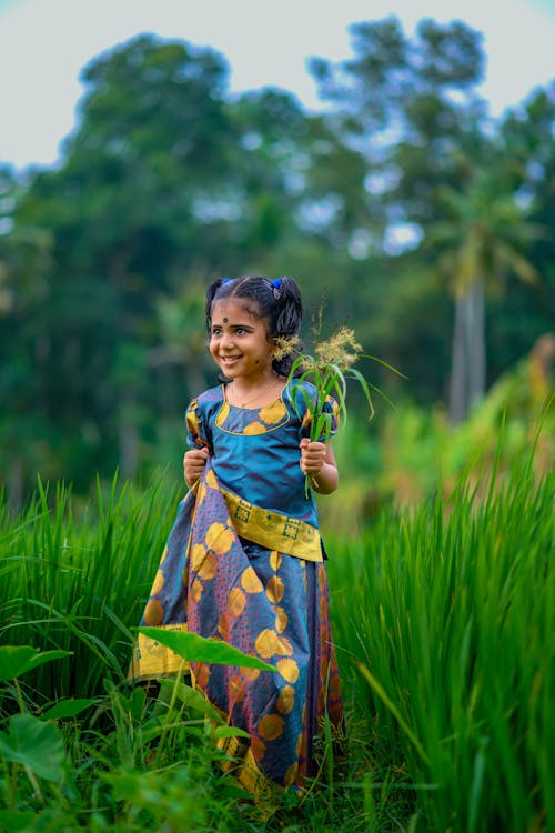 Young Girl Holding Grass Flowers