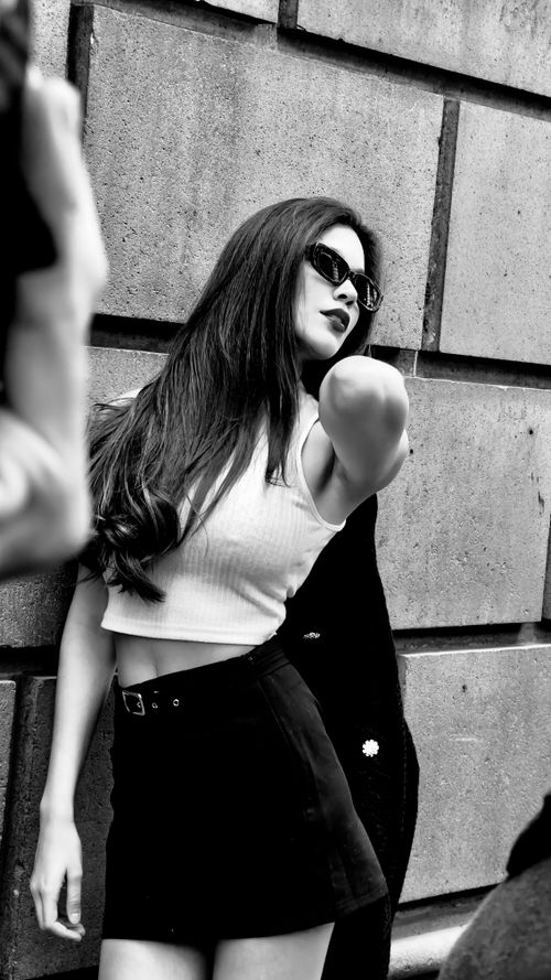 Free Chic woman in black and white attire posing against urban backdrop, exuding modern fashion. Stock Photo