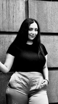Black and white portrait of a woman posing in fashionable attire.