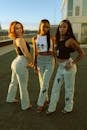 Three Women Wearing Crop Top and Denim Jeans