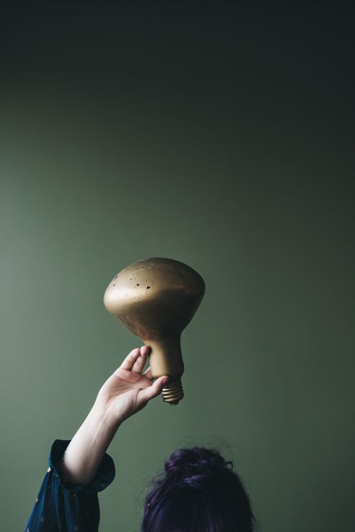 Free A person raises a metallic light bulb symbolizing innovation and creativity. Stock Photo