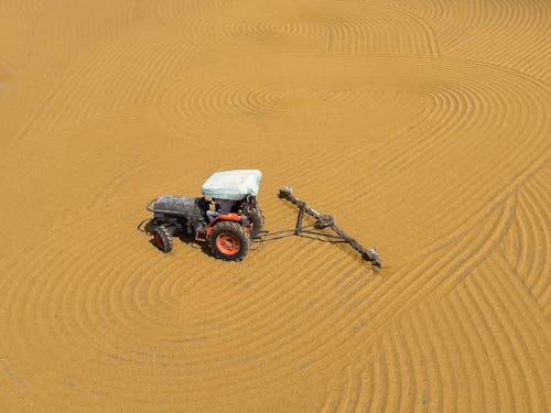 Person Driving a Tractor in Middle of Desert 
