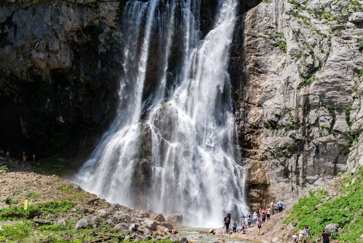 People Standing Near Waterfalls