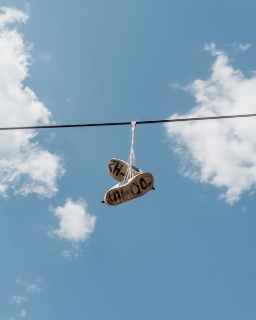 White and Black Sneakers Hanging on Cable Wire