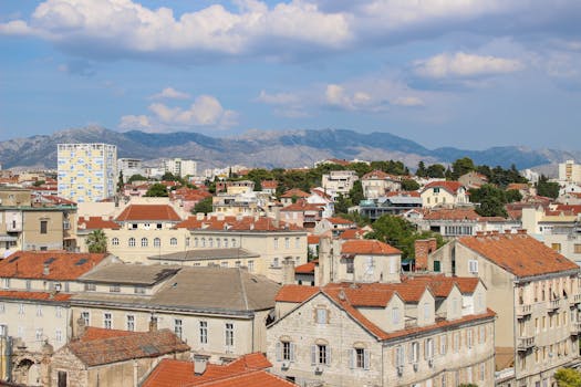 Scenic view of a charming cityscape with Mediterranean architecture and mountain backdrop.