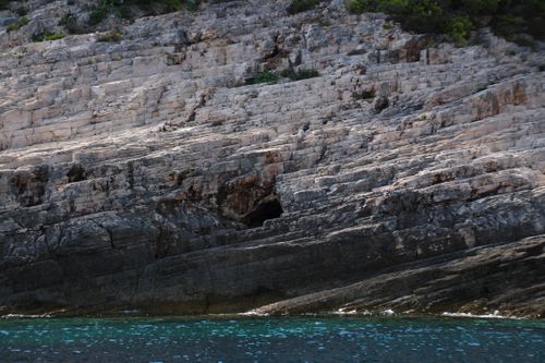Free A rugged rocky cliff beside a calm azure sea, capturing natural beauty and tranquility. Stock Photo