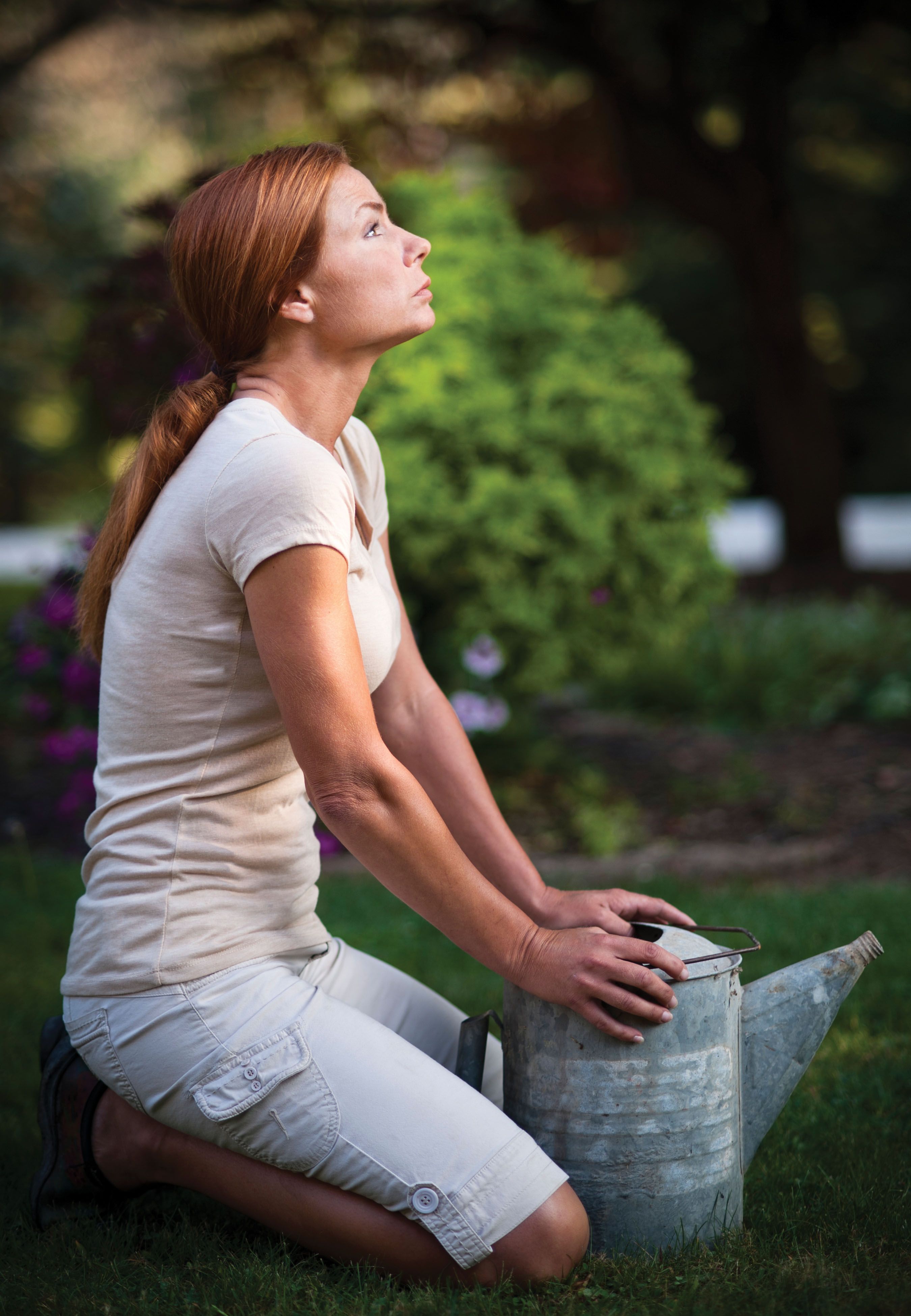 A woman kneeling on green grass free stock photo