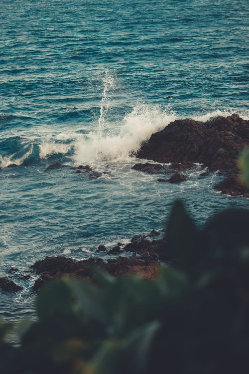 Free Majestic ocean waves crashing on a rocky shoreline, capturing the essence of nature's power. Stock Photo