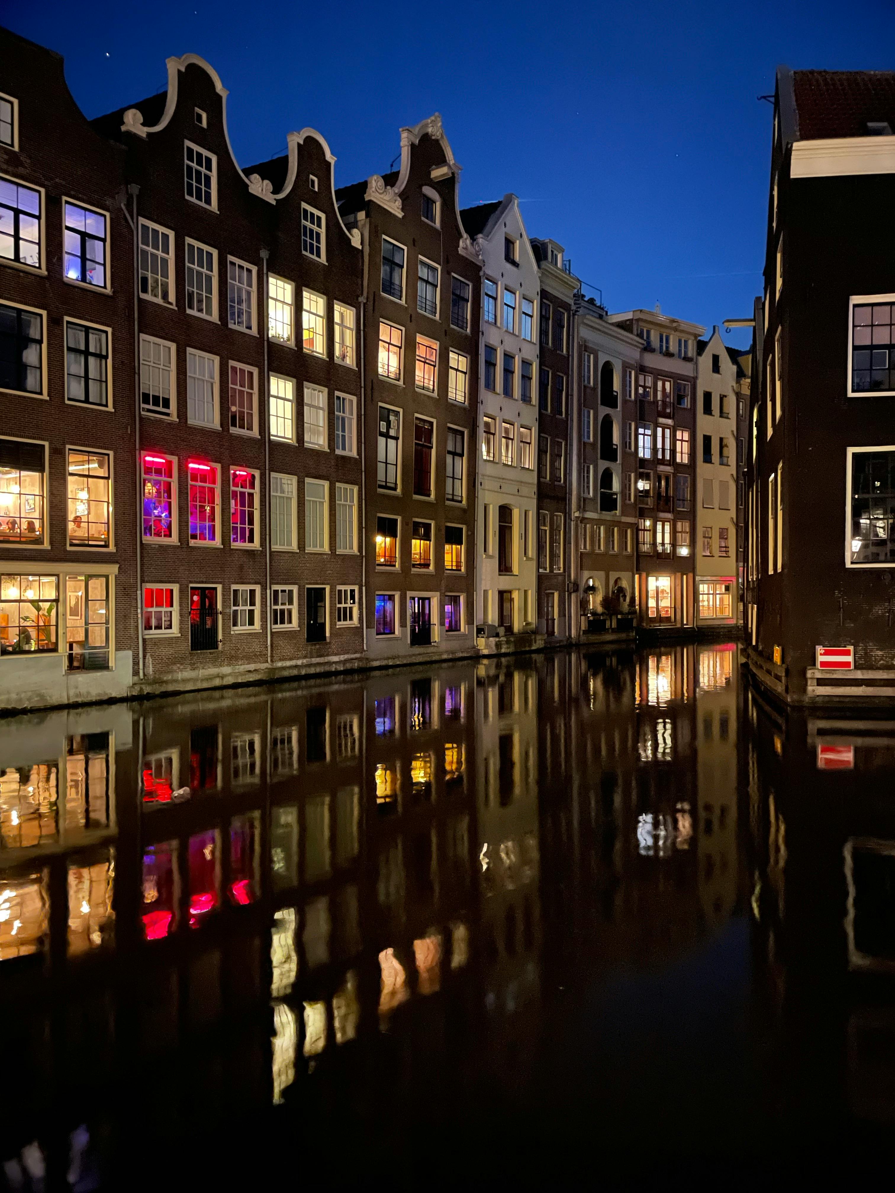 Two friends smiling and playing a video game together on a console with controllers in hand.