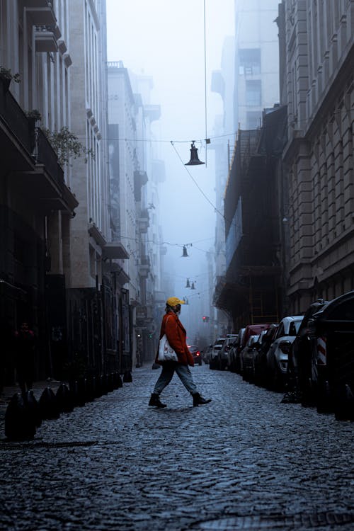 A Person in Red Jacket Walking on the Street