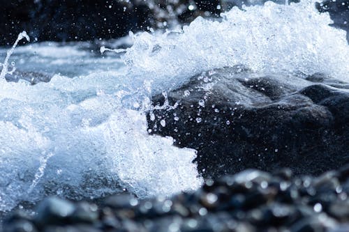 A Close-Up Shot of Water Splashing on a Rock