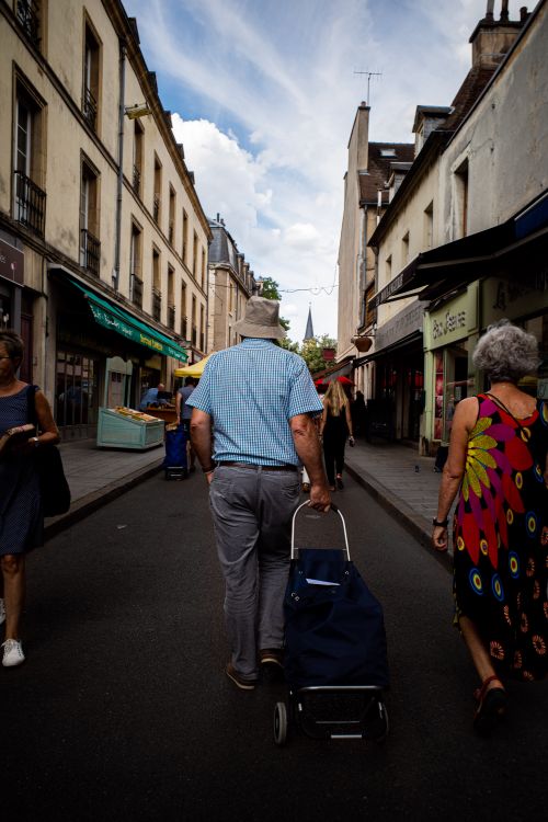 Free Adults walking down a lively urban street, capturing the essence of city life. Stock Photo