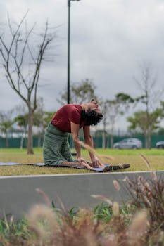 Adult practicing yoga in a serene park setting, showcasing flexibility and mindfulness.
