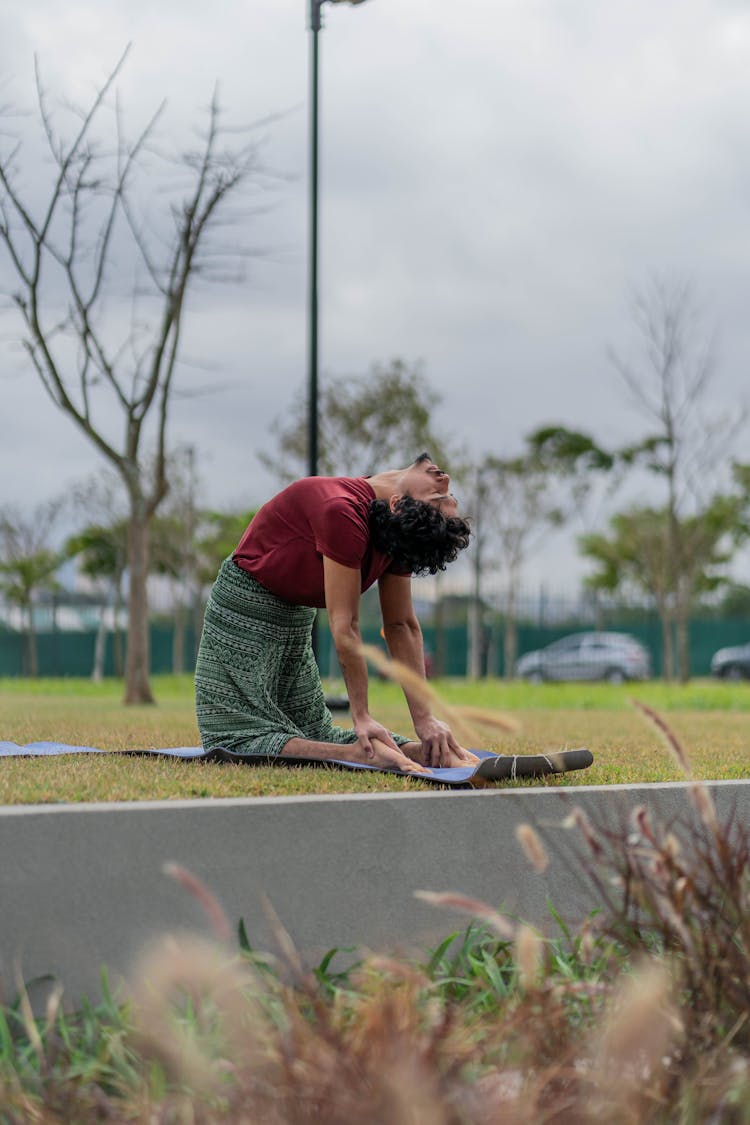 Man In Red T-shirt Doing Yoga At The Park