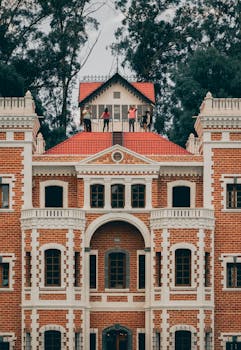 Brick facade of Ex-Hacienda de Chautla with tourists enjoying the view from the rooftop.