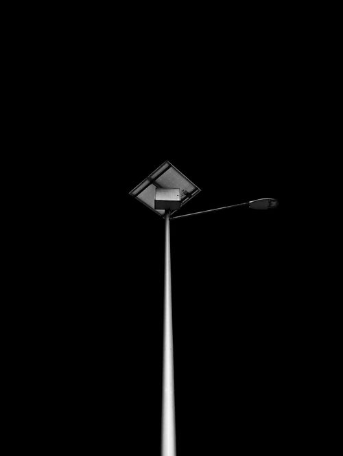 Free Minimalist black and white photo of a street lamp against a dark sky, showcasing urban simplicity. Stock Photo