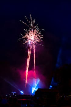 烟花表演引人入胜，鲜艳的红色和蓝色照亮了风景优美的夜空