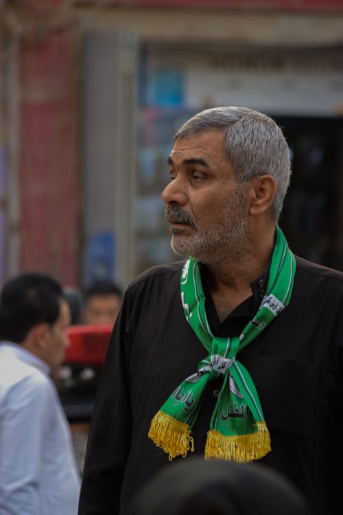Free An adult Middle Eastern man wearing a green scarf, looking to the side. Stock Photo