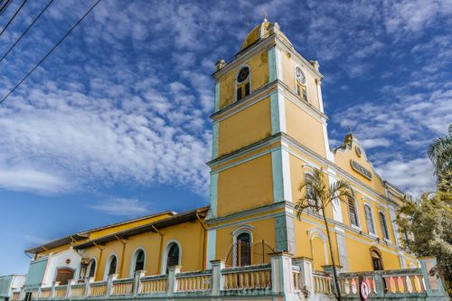 Free Stunning yellow church facade contrasting against a bright blue sky in Itapecerica da Serra, Brazil. Stock Photo
