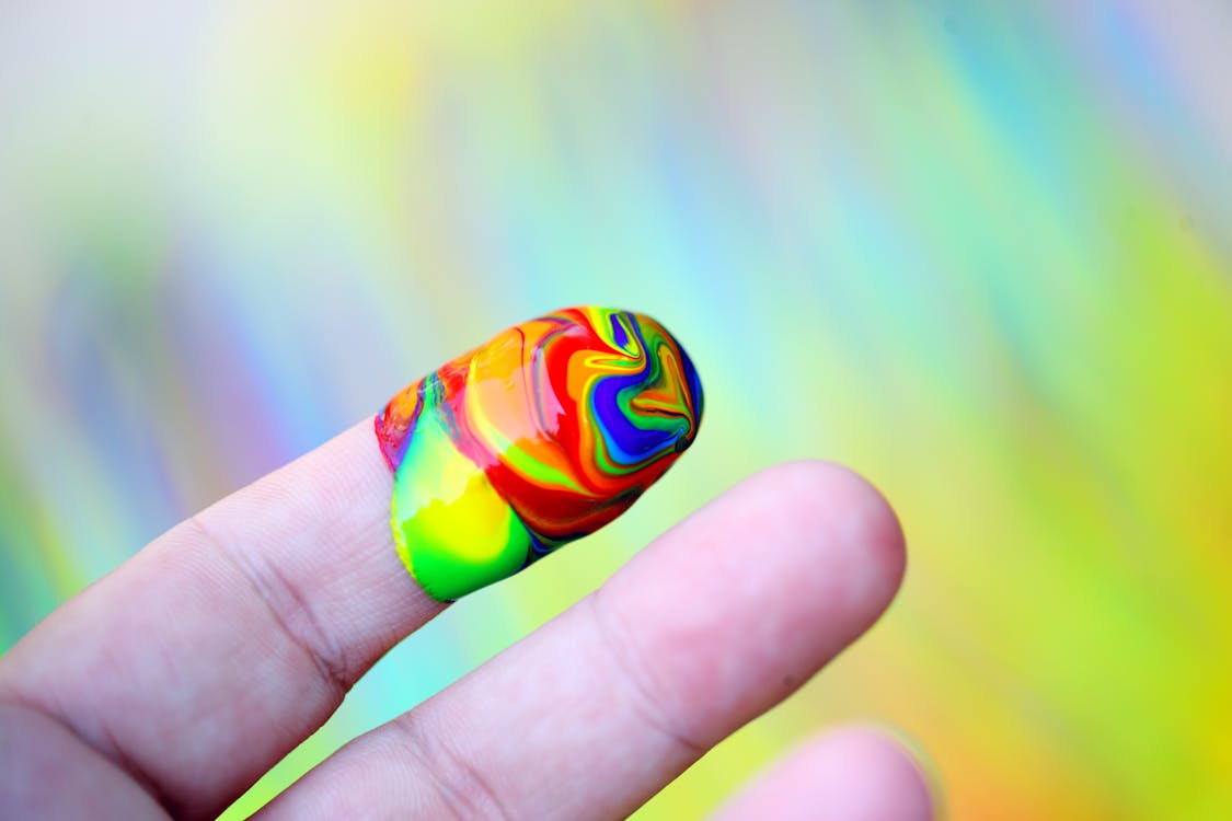 Person Showing Multi-coloured Paint On His Index Finger