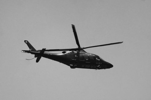 Free Black and white image of a helicopter in flight, showing rotor blades in crisp detail. Stock Photo