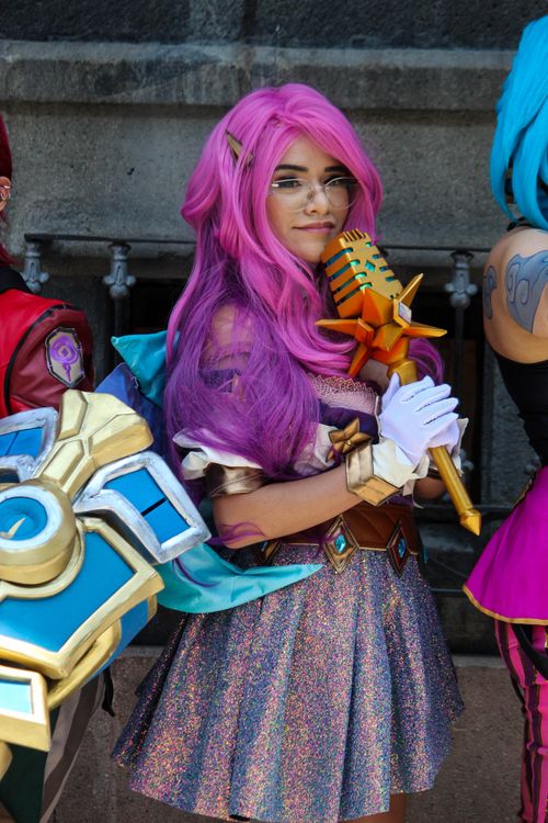 Free Colorful cosplay portrait featuring a woman in fantasy attire with striking pink hair. Stock Photo