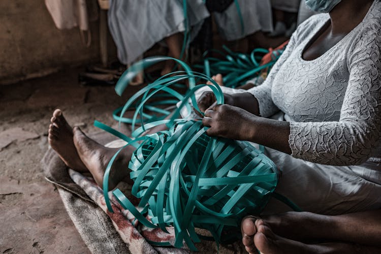 Women Sitting On Ground Making Nets