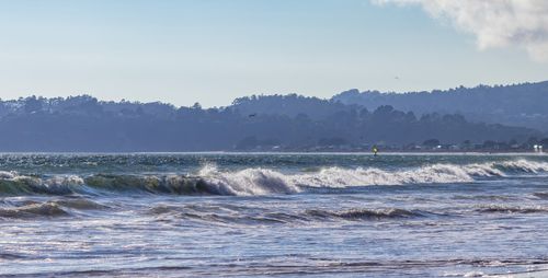 Free Calm ocean scene featuring gentle waves and a distant shoreline under a clear sky. Stock Photo