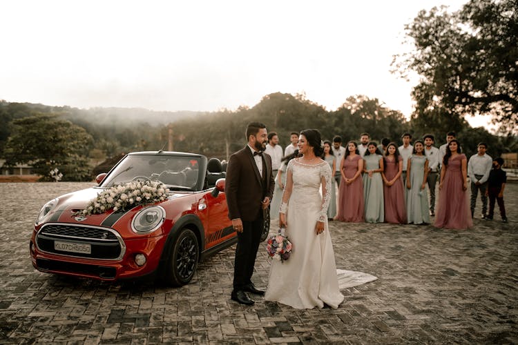 Bride And Groom And Wedding Guests In A Group Behind The Couple 