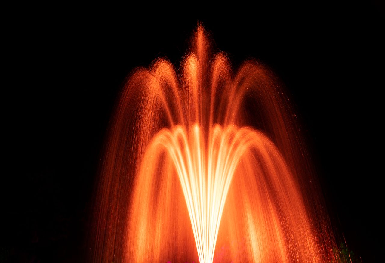 a vibrant night shot of an illuminated fountain with cascading water a